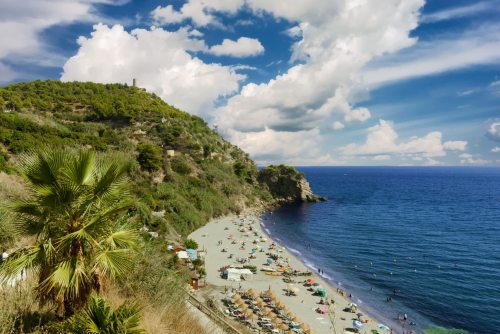 Playa De Maro (Maro Beach) with blue sky with clouds, tourist resort in Costa del Sol, Andalusia, Spain