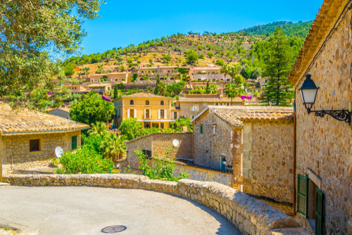 A narrow street with a view of the village of Deia on Mallorca island, Balearic Islands, Spain