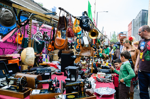 Unidentified people and children shopping at the traditional flea market at Brick Lane, which operates every Sunday in London, England, United Kingdom
