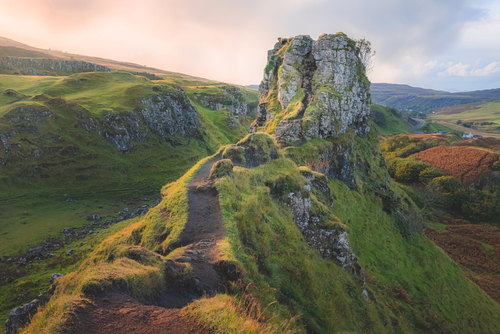 The hilltop tourist attraction Castle Ewan at the Fairy Glen in golden sunset or sunrise light on the Isle of Skye, Scotland, UK