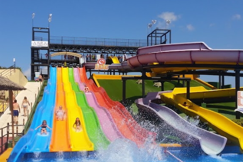 View of people sliding down colorful slides at Hidropark, Alcudia, Mallorca island, Balearic Islands, Spain