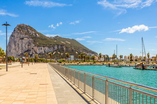 Road to the Rock of Gibraltar with marina on the left and town behind, view from La Linea, Andalusia, Spain