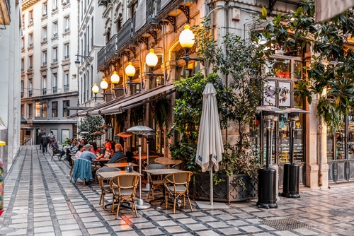Architecture and street view with cafes and stores in the historical city of Granada in Andalusia, Spain