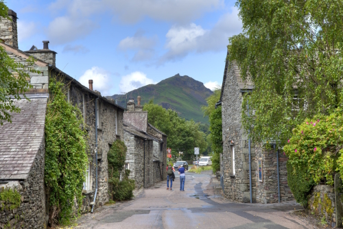 View of people walking down a street in Grasmere, the Lake District National Park, Cumbria, England, UK