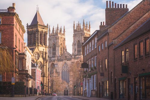 Morning golden light on the historic old town of York along Museum St. looking towards York Minster Cathedral in Yorkshire, England, United Kingdom