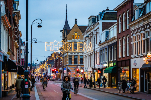 People walking and riding bicycles in one of the streets in Haarlem, The Netherlands at the Evening after Christmas