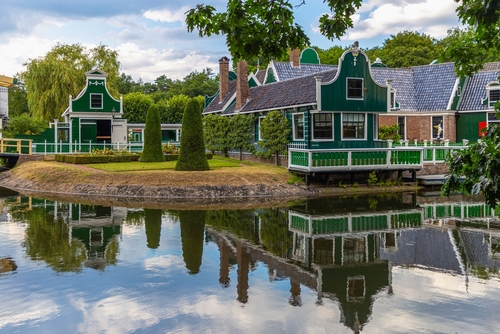 Merchant's house in Dutch Open Air Museum, Openluchtmuseum, Arnhem, Holland, old Dutch building with green authentic facade with reflection in the lake