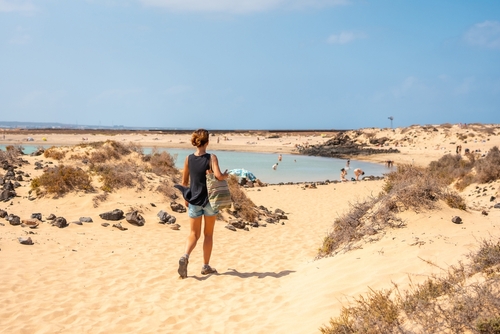 A young tourist visiting La Concha beach on Isla de Lobos, next to the north coast of the island of Fuerteventura, Canary Islands, Spain