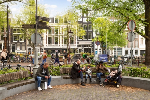 People sitting on a bench at a playground in the Jordaan district near the Prinsengracht in Amsterdam, The Netherlands
