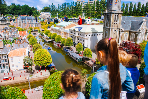 Girls looking at the water and the city in Madurodam miniature park open-air museum, The Hague, The Netherlands