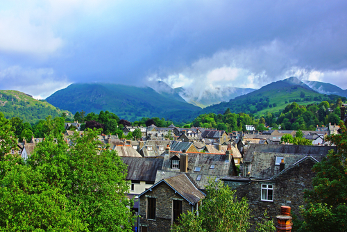 Looking over the roof tops of the town of Ambleside towards the start of the mountain range called The Langdale Pikes, the Lake District National Park, Cumbria, England, United Kingdom