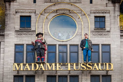 Entrance sign with two figures on the building of Madame Tussaud Museum in Amsterdam, The Netherlands