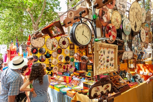 People shopping at El Rastro market stall selling clocks, Madrid, Spain