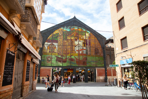 People walking outside the entrance to the Atarazanas market building in Malaga, Andalusia, Spain