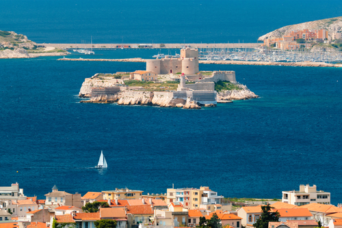View of Marseille town and Chateau d'If castle famous historical fortress and prison on island in Marseille bay with yacht in sea. Marseille, Provence, France