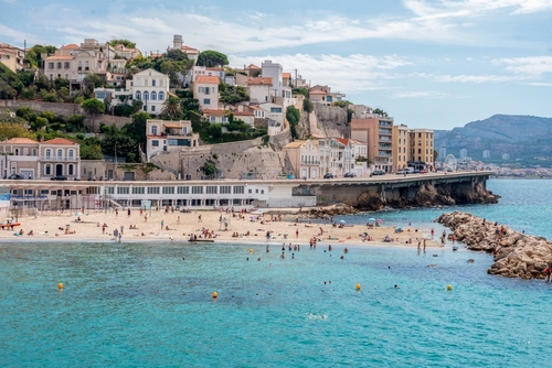 Gorgeous gentle day on the French Riviera - calm light waves and the sun sparkling in the water - people on the beach . This - suburb of Marseille, Provence, France