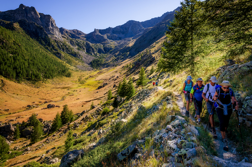 A group of hikers walking on a pathway of the Parc National du Mercantour in Cote d'Azur, France at Sunset