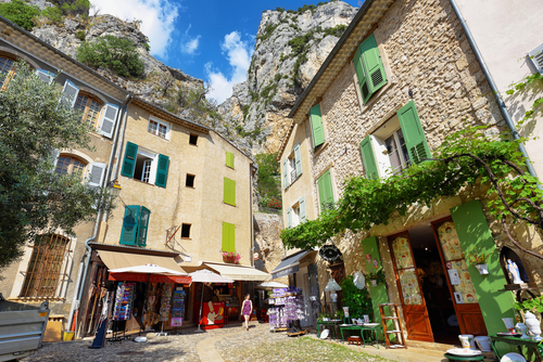 Tourists in the narrow street of the medieval village Moustiers Sainte Marie. Village is included in list of 