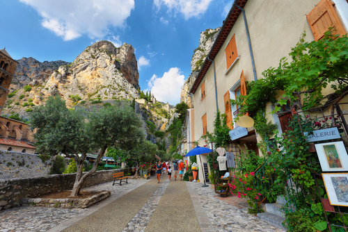 Tourists in the narrow street of the medieval village Moustiers Sainte Marie. Village is included in list of 