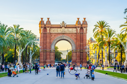 People are strolling through an alley between the arch of triumph and Ciutadella park in Barcelona, Catalonia, Spain