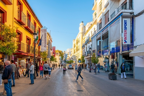 Busy shops and cafes along the main street from the bridge to the bullring in downtown Ronda, Malaga Province, Andalusia, Spain