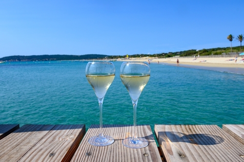 Summer time in Cote d'Azur, two glasses of cold champagne cremant sparkling wine on famous Pampelonne sandy beach near Saint-Tropez, France