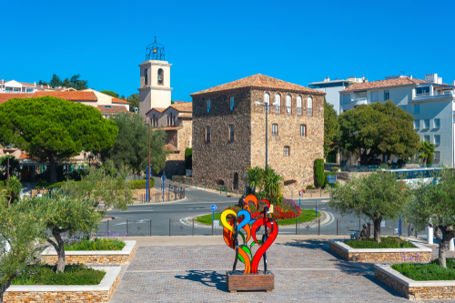 Sculpture on the Quai Leon Condroyer with the Tour Carree and the Catholic Church in Sainte-Maxime near Saint Tropez in the French Riviera, Cote d'Azur, France