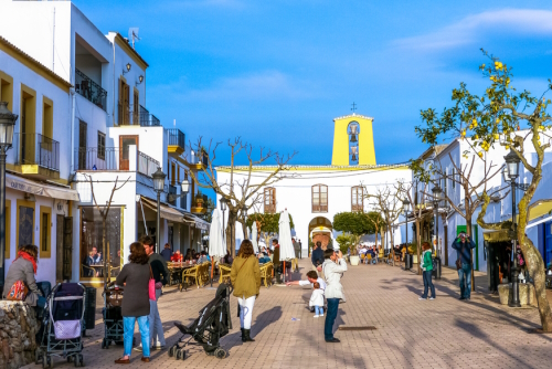 People in the old village center with Santa Gertrudis Church in the background, Santa Gertrudis, Ibiza Island, Balearic Islands, Spain
