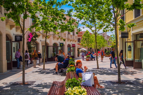 People shopping mall road of La Roca Village on a sunny day with blue sky near Barcelona, Catalonia, Spain