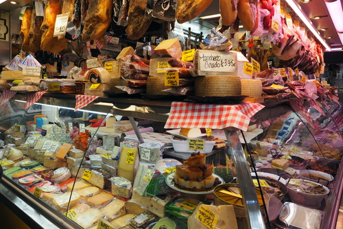 Market stall with a lot of different cheeses inside Mercado Central de Atarazanas, Malaga, Andalusia, Spain