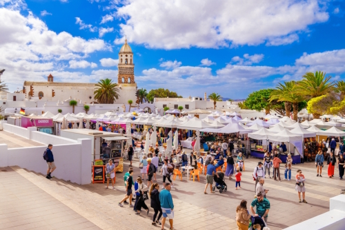 Downtown view with tourists in the local market enjoying shopping on a sunny day near the famous Church of Our Lady in Teguise, Lanzarote Island, The Canary Islands, Spain