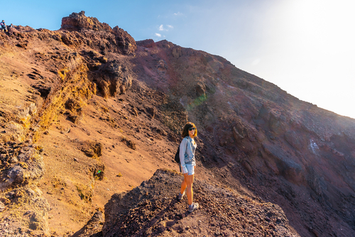 A young woman looking at the crater of the Teneguia volcano on the route of the volcanoes, La Palma island, The Canary Islands, Spain