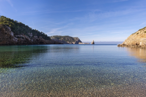 Cala Benirrás beach, a beach with crystal-clear, transparent waters, with an islet at the entrance to the cove, Ibiza island, Balearic Islands, Spain