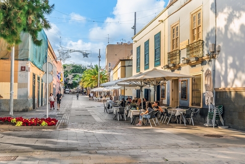 People relax at tables in an open-air cafe on Calle Antonio Dominguez Alfonso street in Santa Cruz de Tenerife, Tenerife Island, Canary Islands, Spain