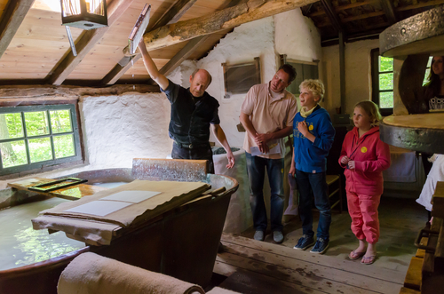 A guide explaining a group of visitors how paper was being made at the Netherlands Open Air Museum, Openluchtmuseum, Arnhem, The Netherlands