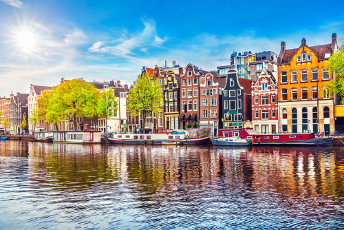 Dancing houses over river Amstel landmark in old european city spring landscape, Amsterdam, Holland