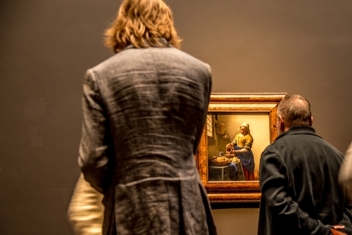 Visitors admire Vermeer's Milkmaid at the Rijksmuseum, Amsterdam, The Netherlands