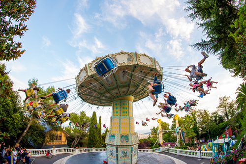 People have fun at the carousel flying swing ride attraction at Tibidabo Amusement Park in Barcelona, Catalonia, Spain