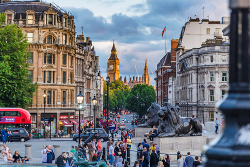 Street view of Trafalgar Square in London, England, UK, Big Ben tower in the background, people walking through the square