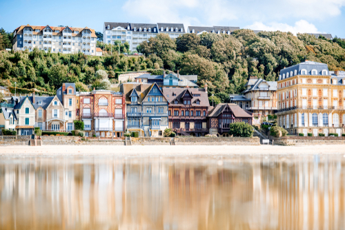 View on the cooastline with sandy beach and luxury buildings in Trouville, famous french town in Normandy, France