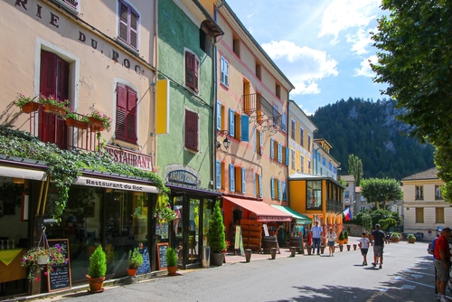 Square with colorful facades and window shutters in the Provencal village of Castellane in the southern Alps, Provence, France