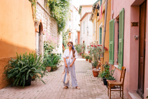 A woman standing in the middle of a street in the village of Villefranche-sur-mer, the French Riviera, Cote d'Azur, France