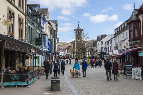People walking through the beautiful town centre in Keswick, located in the Lake District National Park, Cumbria, England, UK