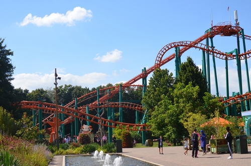 Large colorful rollercoaster and people walking in Walibi Holland amusement park in Biddinghuizen, Flevoland, The Netherlands
