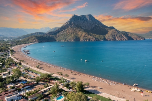 View of the long beach coast and its facilities, dark teal sea and bay in Adrasan village Mediterranean coast, Antalya, Turkey