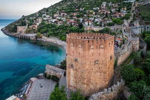 Aerial view of ancient shipyard near of Kizil Kule tower in Alanya peninsula, Antalya, Turkey. Famous tourist destination with high mountains, part of an ancient old Castle