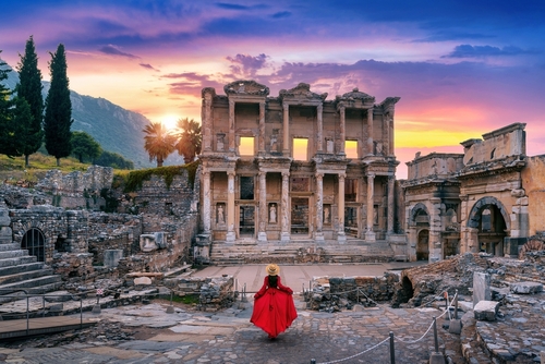 Woman standing in Celsus Library at Ephesus ancient city, dramatic lighting scene in Izmir, Turkey