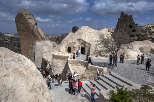 Visitors to the Open Air Museum near Goreme in the Cappadocia region of Turkey file out of the Chapel of St Basil containing the fresco of Jesus Christ