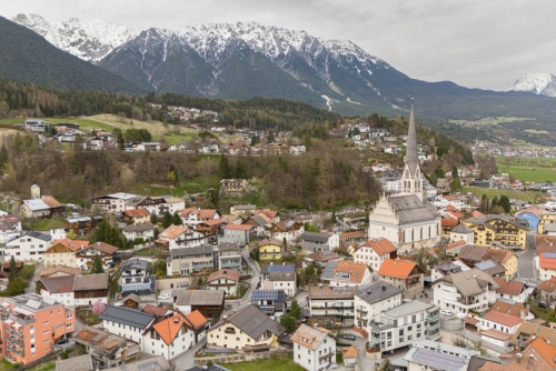 Aerial winter view of the city centre of Imst in Tirol, Austria. Beautiful city view with Rauchberg and Heiterwand mountain in the background and Pfarrkirche Imst
