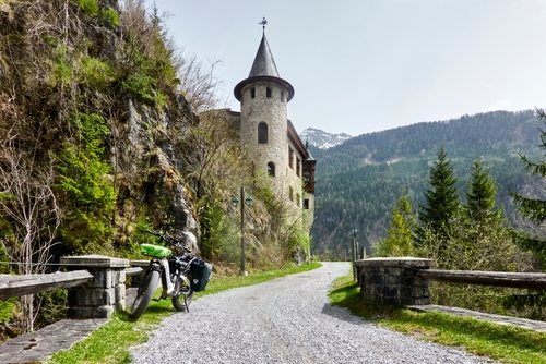 E-Fatbike on the Edge of a Gravel Path in the Alps with a Small Castle in the background near Imst, Tirol, Austria